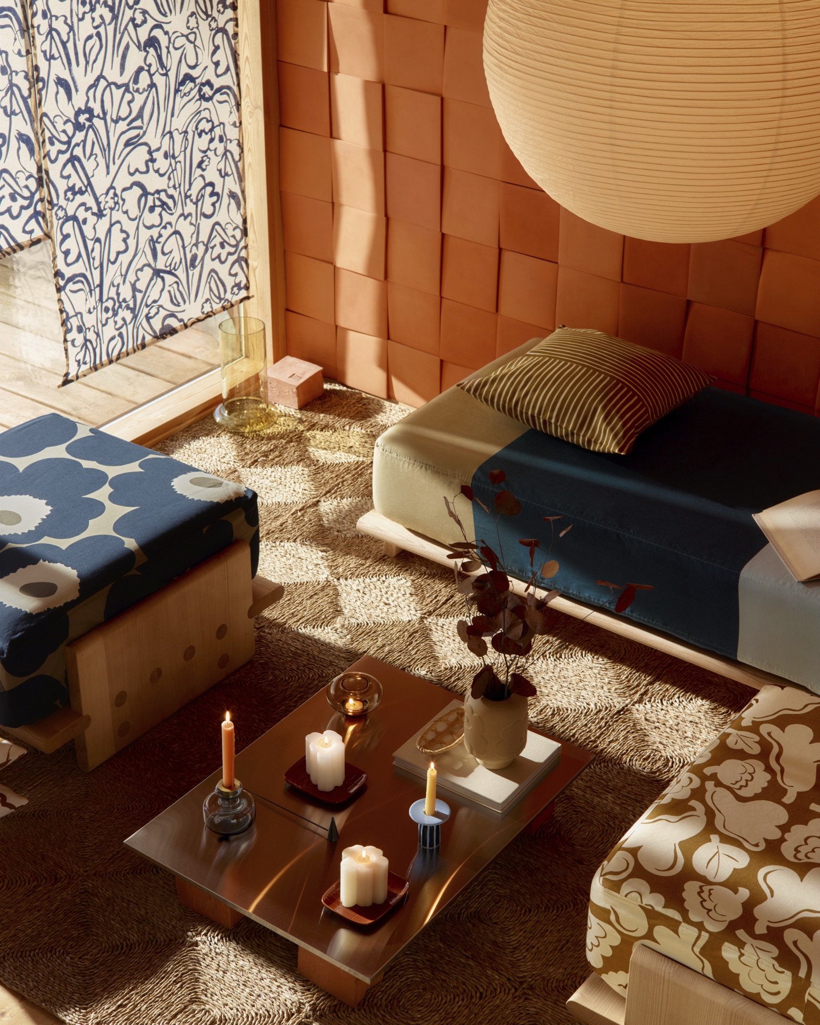 Intérieur baigné de soleil : poufs aux imprimés Marimekko, table basse en laiton, tapis tressé